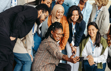Diverse group of professionals taking a cheerful selfie together during a casual team meeting