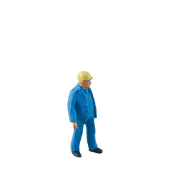 Miniature construction worker dressed in a blue jumpsuit isolate on white background with clipping path