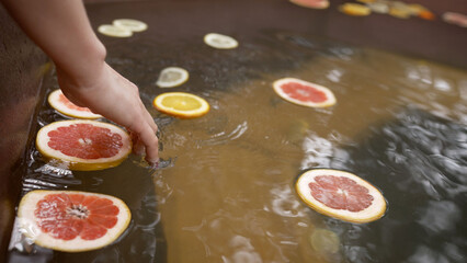 Grapefruit slices floating in hot tub as someone enters