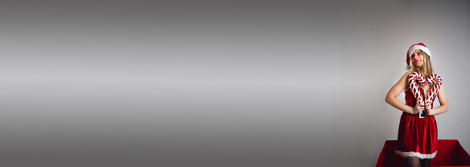 Miss Santa Claus with a gift in a huge red box, Christmas concept,space for text, size for banner