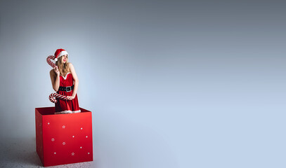 Miss Santa Claus with a gift in a huge red box, Christmas concept,space for text, size for banner