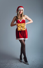 Miss Santa Claus with a gold gift, Christmas concept