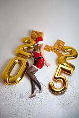 Miss Santa Claus lies on a white background surrounded by gifts and the inscription 2025, top view