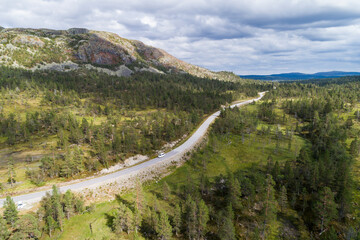 Aerial high angle view of river and road running through forest and mountains