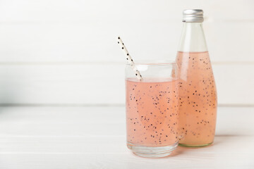 Diet detox cocktail with basil and chia seeds in a glass jar and a glass on a textured background....