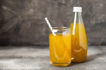 Diet detox cocktail with basil and chia seeds in a glass jar and a glass on a textured background....