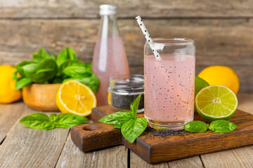 Diet detox cocktail with basil and chia seeds in a glass jar and a glass on a textured background....