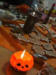 Delicious Halloween snacks shaped like mummies, eyes, and pumpkins, with pumpkin-shaped candles in the background, create a festive atmosphere.