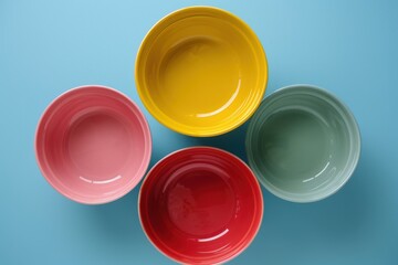 Four colorful ceramic bowls arranged on a blue background