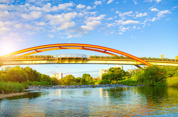 Obraz premium Steel bridge over river with sunset in countryside.
