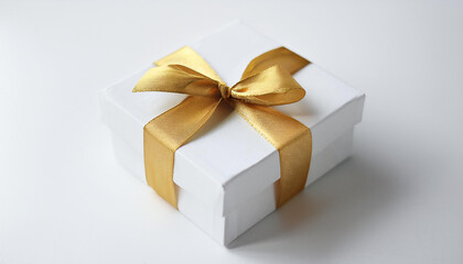 White gift box tied with shiny golden ribbon. Present for holiday. Christmas or New Year concept.