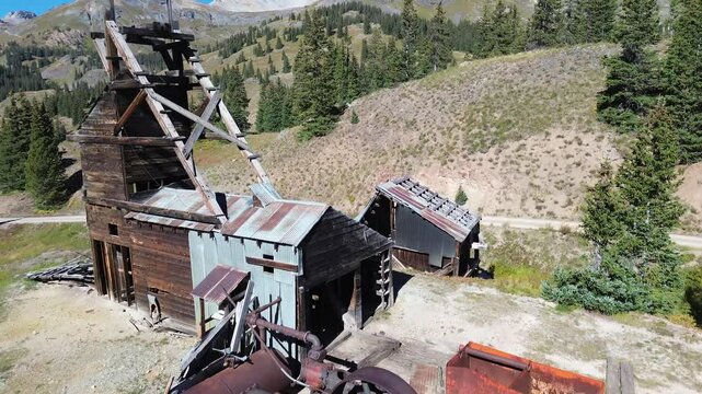 Abandoned Longfellow Mine between Silverton and Ouray, Colorado. Rising shot features the intact air compressor system that remains on the site with a mountain view beyond.