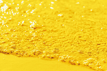 A slow bright golden stream of bubbling liquid