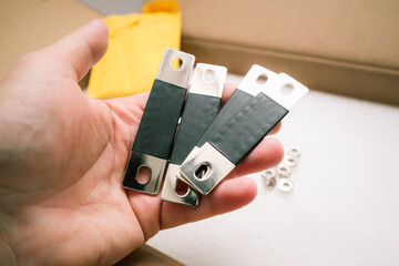 Mans hand with copper bus bar for lifepo4 prismatic cell battery