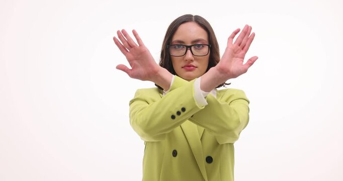 Serious businesswoman crosses arms to show refusal on white background. Attractive female in bright blazer refuses to participate in discussion