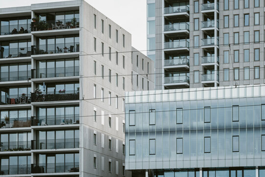 The image showcases a set of modern apartment buildings characterized by their glass facades and balconies, symbolizing urban living and architectural elegance.