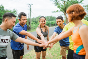 asian athlete putting their hands together as a team