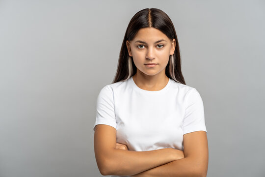 Independent confident teenage girl stare at camera, stand with folded arms and fearlessness view on gray isolated background. Rebellious schoolgirl with strong will, free spirited youth. Girl power, 