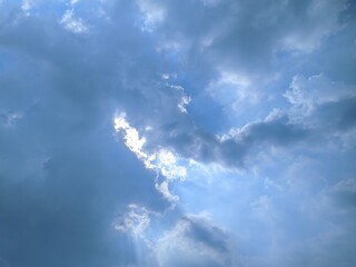 Dramatic sky with dark clouds and a ray of sunlight breaking through, creating a striking contrast. Perfect for moody, atmospheric visuals.