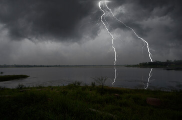 Strong lightning on the shore of the lake