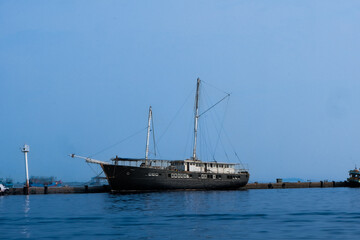 Scenic view of a tranquil dock with a boat gently floating on calm waters. The serene setting features soft lighting and reflections, evoking a peaceful and timeless atmosphere by the water's edge.