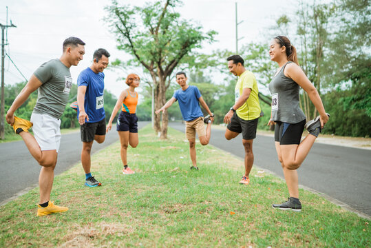marathon runners in sportswear warming up together before competition