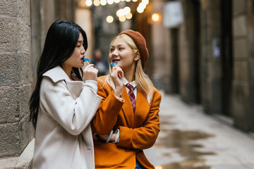 Two young tourists having fun eating lollipops in barcelona