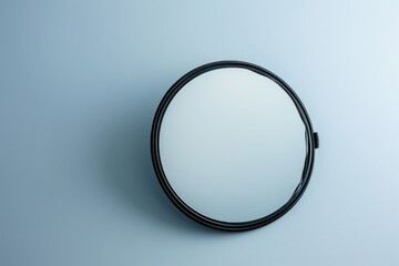 Fototapeta premium Simple round mirror on a pale blue background showcasing its reflective surface and clean design