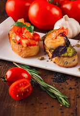 Delicious italian bruschetta with tomatoes and shrimps lying on white plate