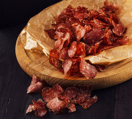 Slices of delicious cured meat served on wooden board with beer
