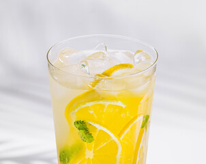 Refreshing cold lemonade with lemon slices and mint in glass with ice cubes