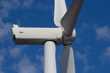 Close-up of wind turbine against blue sky. Concept of green, clean, renewable energy.