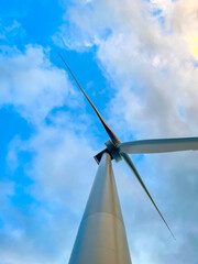 Close-up of wind turbine against blue sky. Concept of green, clean, renewable energy.