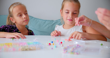 Girls Creating Beaded Jewelry at Home with Their Mom