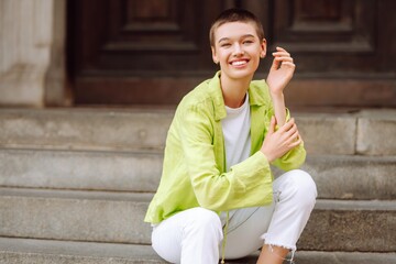 Fototapeta premium Happy short-haired woman walks through the city streets. Lifestyle, fashion, travel concept.