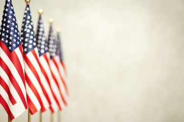 Row of American flags on stands with blurred backdrop.