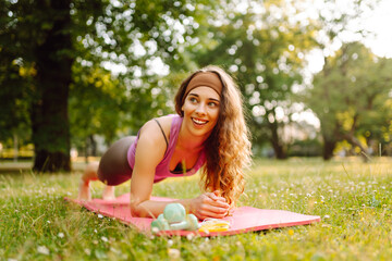 Young slim woman doing stretching or yoga relaxing exercise at public park. Lifestyle and Meditation concept.