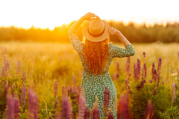 Beautiful woman at purple lavender field with with a bouquet of wild flowers. Concept freedom joy lifestyle. Medicinal herbs.
