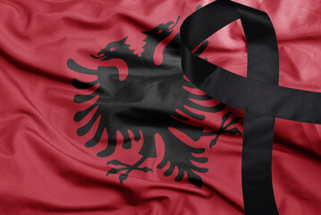 waving national flag of albania with black mourning ribbon .tragedy concept