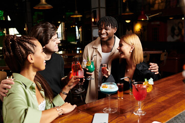 A cheerful gathering of diverse colleagues sharing cocktails and stories at a corporate celebration.