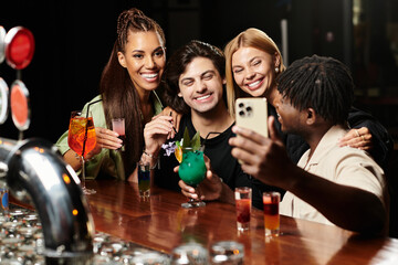 Colleagues celebrate together, sharing drinks and smiles while capturing a joyful moment.