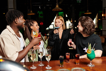 Colleagues celebrate together, sharing laughs and cocktails at a lively corporate gathering.