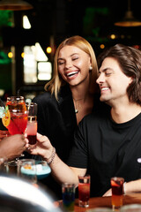 Young professionals laugh and toast at a corporate party, sharing memorable moments.