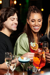 Colleagues celebrate together with cocktails, sharing smiles and laughter at a lively event.