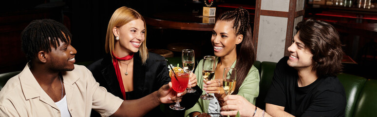 Diverse young professionals enjoy drinks and laughter together at a lively corporate gathering.