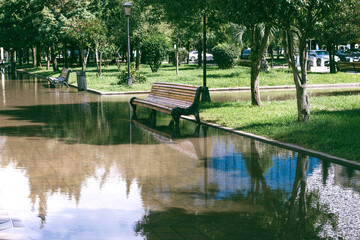 flooded boulevard park with bench after heavy rains
