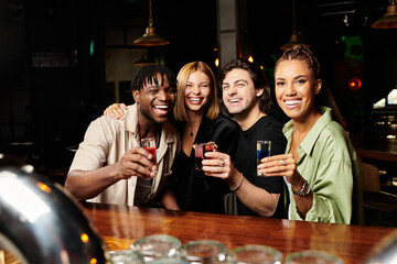 A cheerful group of young professionals toasts at a festive corporate event.