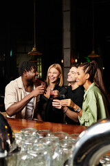 Young professionals share laughter and drinks at a vibrant corporate celebration.