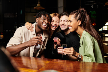 Diverse colleagues joyfully share drinks and laughter during a vibrant corporate celebration.