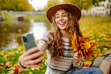 Happy Tourist enjoys the weather, takes a photo with a yellow leaf. Travel blog. Selfie time.